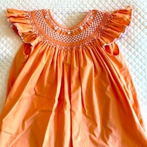 Orange sherbet smocked dress with pearls.